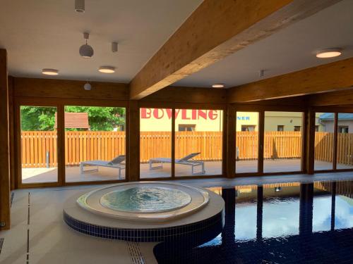 a swimming pool with a tub in the middle of a building at Apartmany Arber in Železná Ruda