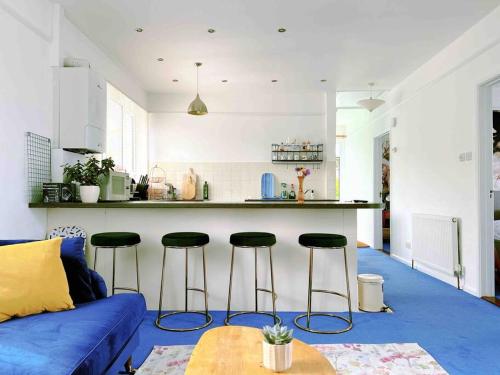Il comprend un salon avec un canapé bleu et une cuisine. dans l'établissement Shan Mu Inn Entire flat 2 bedrooms with terrace seaview BBQ, à Newlyn