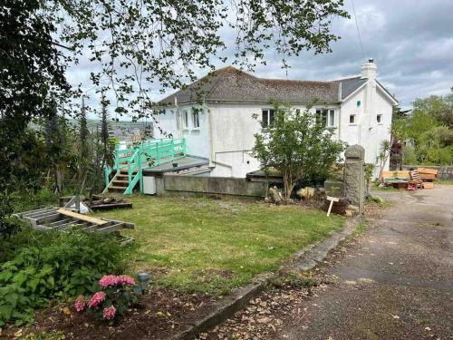 a small white house with a yard with a yard at Shan Mu Inn Entire flat 2 bedrooms with terrace seaview in Newlyn