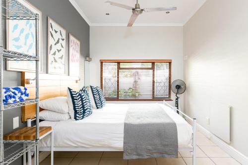a bedroom with a bed and a window at Camps Bay Village - Beach Studios in Cape Town