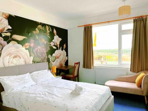 - une chambre avec un lit et un mur fleuri dans l'établissement Shan Mu Inn Entire flat 2 bedrooms with terrace seaview BBQ, à Newlyn