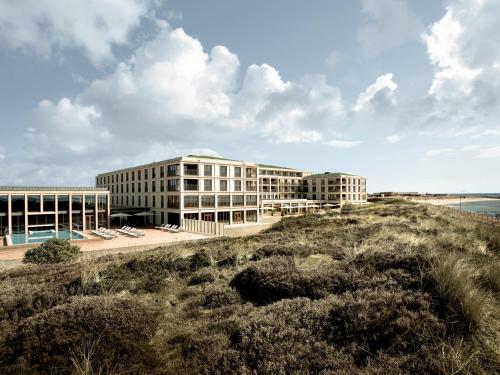 a building on the beach next to the ocean at A-ROSA Sylt in List