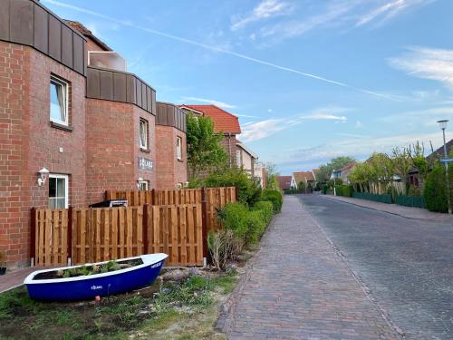 a blue boat sitting on the side of a house at Ferienwohnung Gustav - Moderne Maisonette-Wohnung mit Terrasse in Wangerooge
