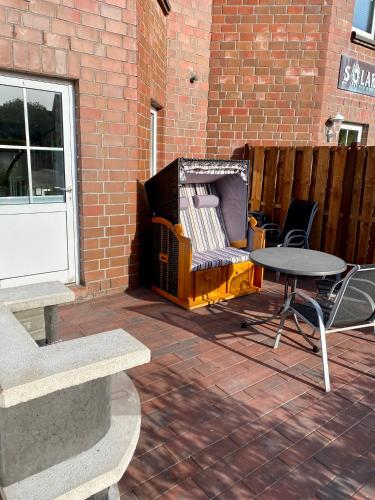 a patio with a table and a table and a fence at Ferienwohnung Gustav - Moderne Maisonette-Wohnung mit Terrasse in Wangerooge