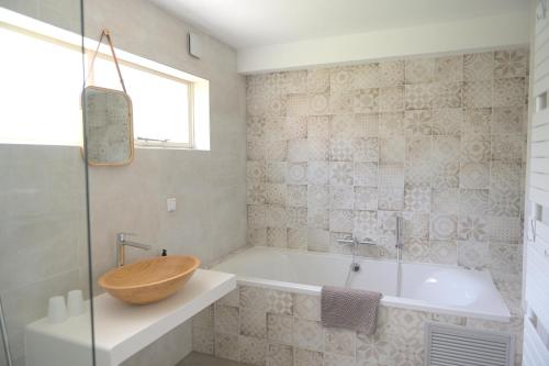y baño con bañera y lavamanos con un bol de madera. en AaBenB appartement en Tilburg