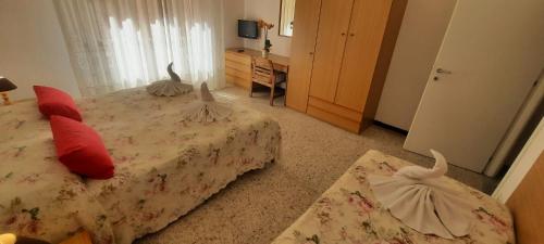 a bedroom with two beds with red pillows at Hotel Dora in Levanto