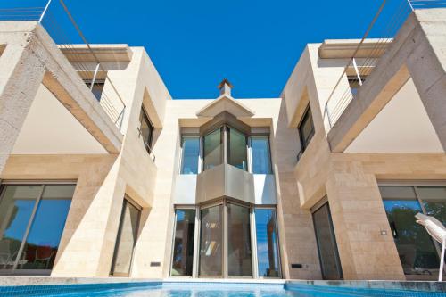 un edificio con piscina frente a él en Herce Property - Minimalist & Mediterranean, en Llucmajor