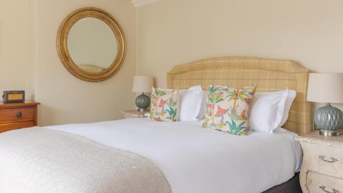 a bedroom with a white bed with pillows and a mirror at The Bear Hotel in Wareham