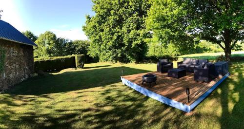 a wooden deck with a couch and chairs on it at La Martinière in Saint-Aubin-Fosse-Louvain