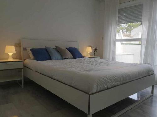 マルベーリャにあるDuplex in Lunamar Complexのベッドルーム(青い枕の大型ベッド1台付)