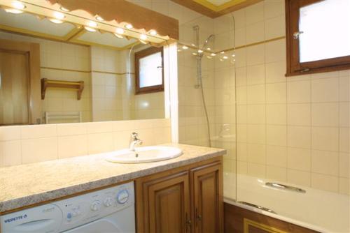 une salle de bain avec un lavabo et un miroir dans l'établissement CHALET HOLIDAY, aux Gets