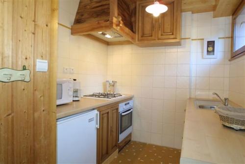 une cuisine avec un évier et une cuisinière four supérieur dans l'établissement CHALET HOLIDAY, aux Gets