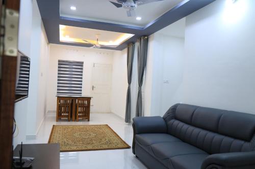 a living room with a couch and a table at Yelza Hotel and Residence in Alwaye