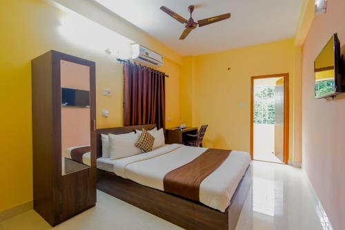 a bedroom with a bed and a desk in a room at Eco Corporate Inn in Kolkata