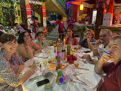 a group of people sitting at a table eating at Hôtel Restaurant Coco Lodge Majunga in Mahajanga