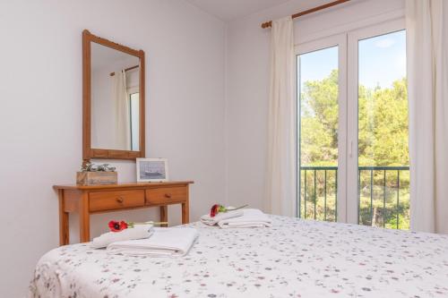 a bedroom with a bed with a mirror and a window at Filippi in Son Parc