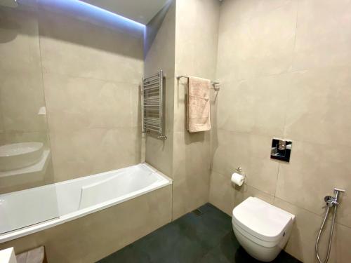 a bathroom with a toilet and a tub and a sink at Heart of Yerevan - City Center Luxury Apartments in Yerevan
