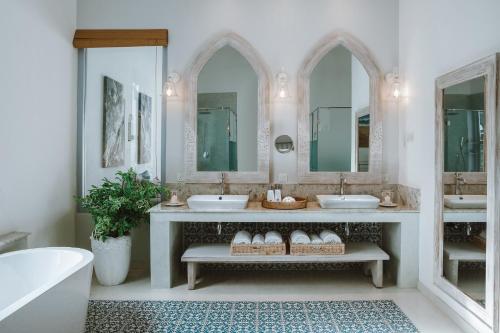 ein Badezimmer mit zwei Waschbecken und zwei Spiegeln in der Unterkunft Selenya Talpe - Boutique Villa in Unawatuna