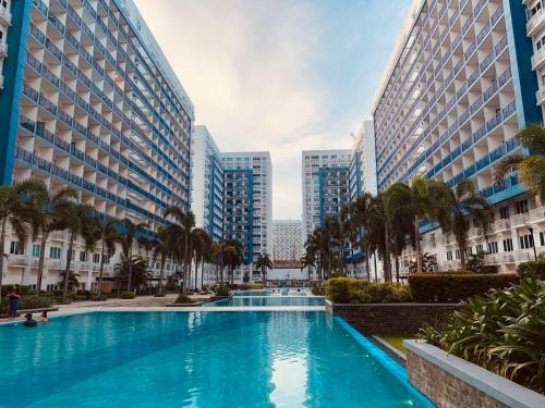 a swimming pool in the middle of two tall buildings at Sea Residences MOA Manila by JO in Manila