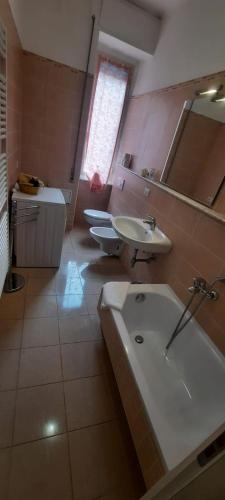 a bathroom with two sinks and a tub and a mirror at Hotel Dora in Levanto