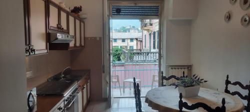 a kitchen with a table and a view of a balcony at Hotel Dora in Levanto