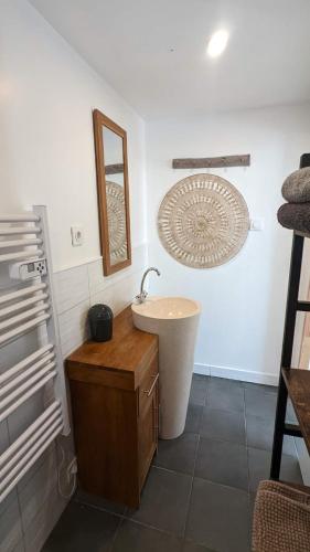 ein Bad mit einem Waschbecken und einem Wandspiegel in der Unterkunft Ikigai in Muhlbach-sur-Munster