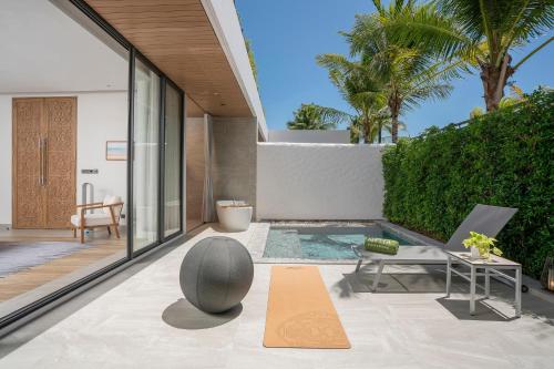 an indoor patio with a pool and a table and a chair at Meliá Phuket Mai Khao in Mai Khao Beach