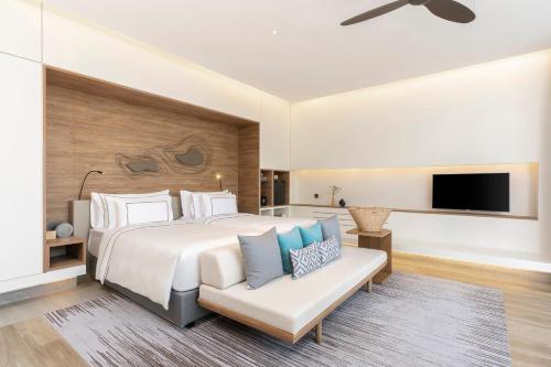 a bedroom with a large white bed and a couch at Meliá Phuket Mai Khao in Mai Khao Beach