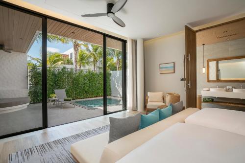 um quarto com uma cama e vista para uma piscina em Meliá Phuket Mai Khao em Praia de Mai Khao