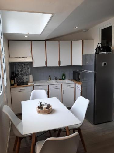 a kitchen with a white table and a black refrigerator at Home-Sweet-Home Superbe appartement en hypercentre in La Rochelle