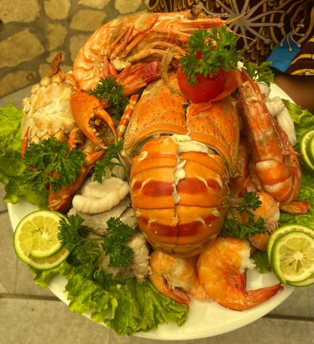 a plate of food with lobster and shrimp and lettuce at Hôtel Restaurant Coco Lodge Majunga in Mahajanga
