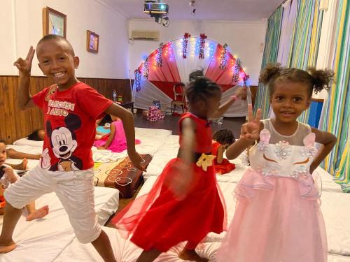 two children are dancing on beds in a room at Hôtel Restaurant Coco Lodge Majunga in Mahajanga