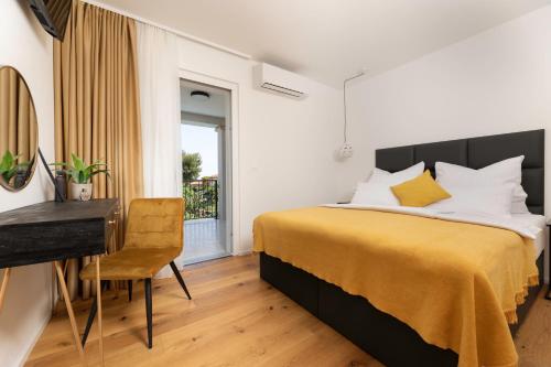 Un dormitorio con una cama y un escritorio y una ventana. en Villa Pafran with heated pool Krk, en Krk