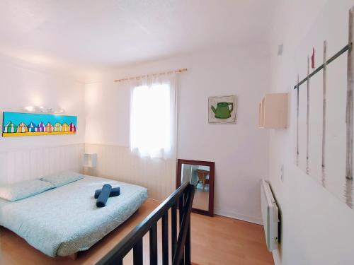 um quarto com uma cama com uma almofada azul em Lalanne Btz, Duplex Jardinet près de la Plage em Biarritz