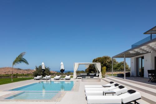 Villa con piscina y muebles blancos. en Alma Villa, 2000m2 Luxury Living, by ThinkVilla, en Angeliana