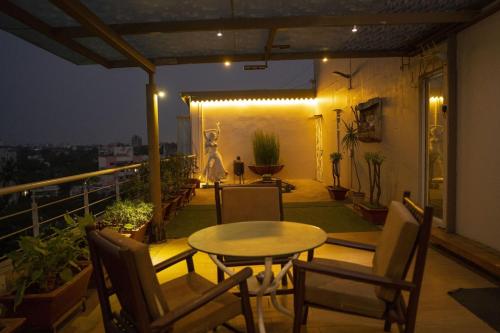 a table and chairs on a balcony at night at Chandralok Service Apartments in Kolhapur
