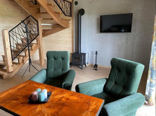 a living room with two chairs and a table and a television at Na starej drodze in Ciche