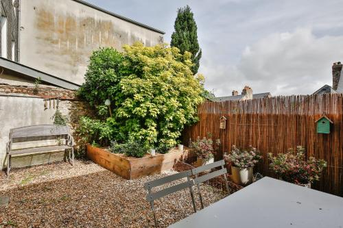 einen Garten mit einer Bank neben einem Zaun in der Unterkunft Le Jardin d'Eugene - 4P House - Terrasse - Historisches Zentrum in Honfleur