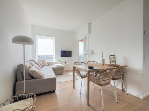 a living room with a couch and a table and chairs at New Danish Design flat - 10 minutes to city centre in Copenhagen