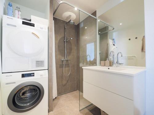 a bathroom with a washing machine and a shower at New Danish Design flat - 10 minutes to city centre in Copenhagen