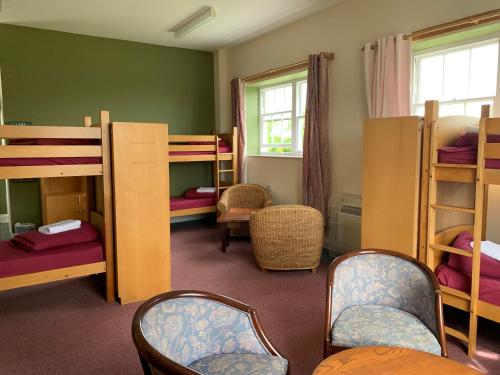 a room with bunk beds with chairs and a table at Jersey Accommodation and Activity Centre in Gorey