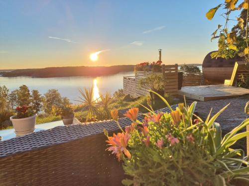 a view of a lake from a patio with flowers at Nils Bastu Spa och Övernattningstuga in Tyresö