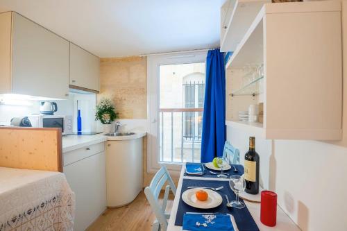 - une petite cuisine avec une table dans un petit appartement dans l'établissement GuestReady - "Boat-Cabin" Inspired Apartment in the Heart of Bordeaux, à Bordeaux