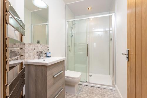 La salle de bains est pourvue d'une douche, de toilettes et d'un lavabo. dans l'établissement Railway Cottage, Newtyle, à Newtyle
