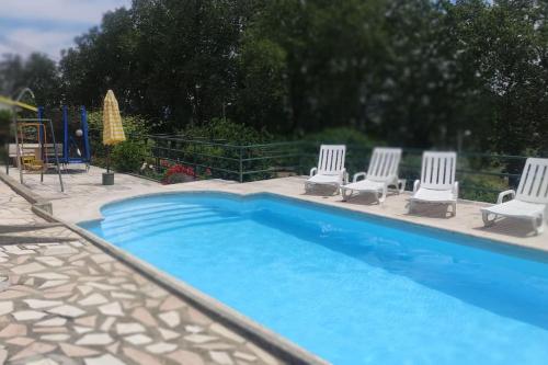 a swimming pool with four chairs at Refúgio Serrano Covilhã Serra da Estrela in Covilhã