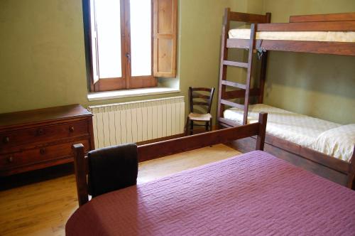a bedroom with two bunk beds and a table and a window at Rifugio Casello Margherita in Camigliatello Silano