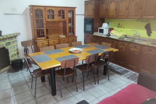 a kitchen with a wooden table and some chairs at Refúgio Serrano Covilhã Serra da Estrela in Covilhã