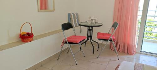 a table and chairs in a kitchen with a table and a window at Platia Studios in Matala