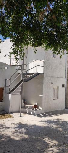 a building with a staircase on the side of it at Platia Studios in Matala
