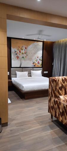a bedroom with two beds and a painting on the wall at HOTEL SUNRISE HOSPITALITY in Vijayawāda